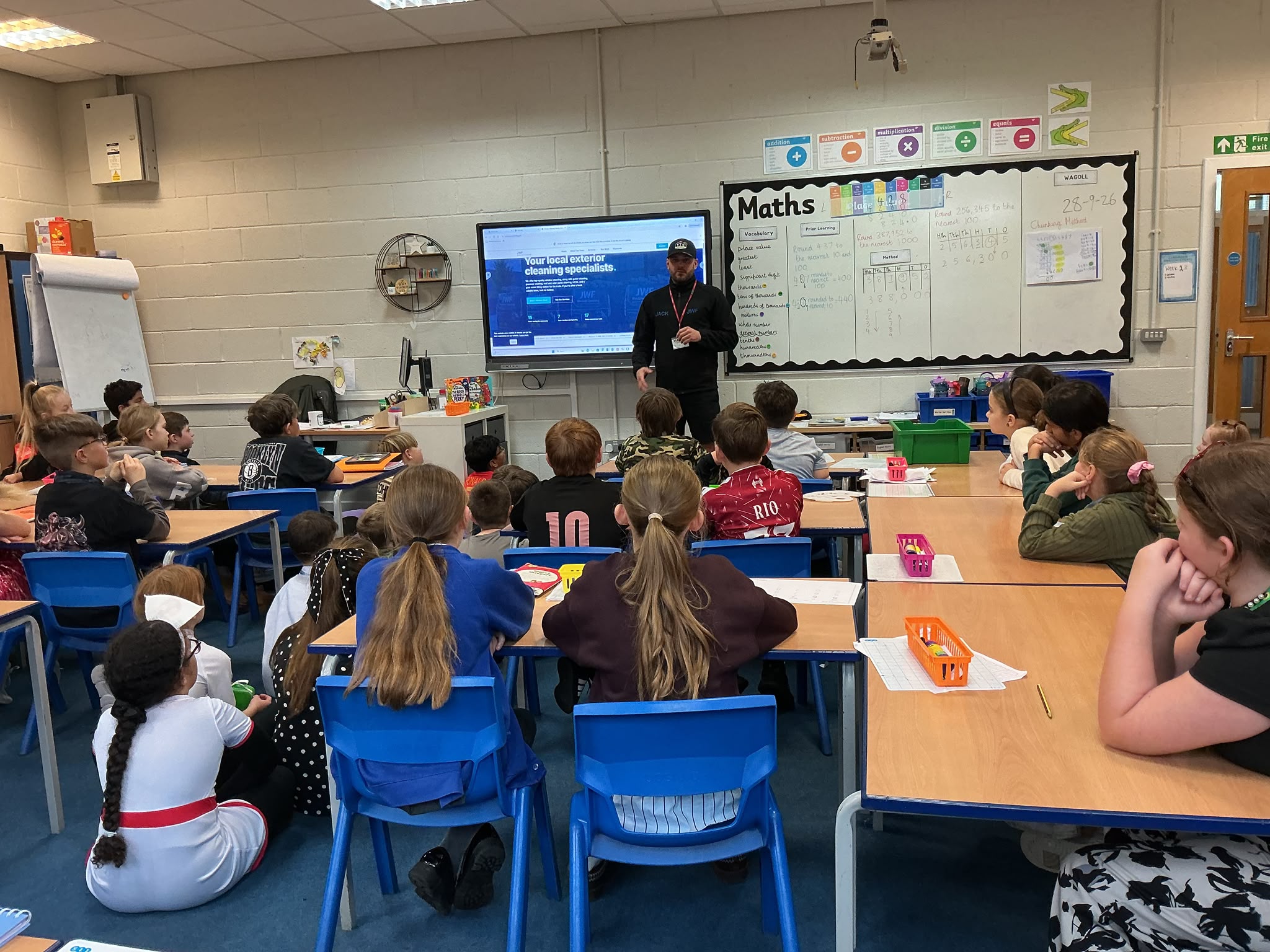 Jack Fairburn of JWF Window Cleaning presenting to a Brunshaw Primary School class, with the JWF website on the classroom screen